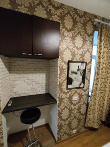 - une cuisine avec un comptoir et un tabouret dans une pièce dans l'établissement Ruska Apartments, à Lviv