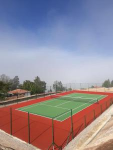 una pista de tenis con verde y rojo en El Bosque de Paipa, en Paipa