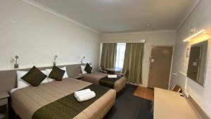 a hotel room with a bed and a couch at Sapphire City Motor Inn in Inverell