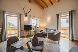 ein Wohnzimmer mit einem Sofa, einem Tisch und Stühlen in der Unterkunft Ferienwohnungen Wiesbauer in Schenna