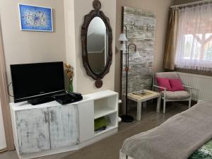 a living room with a tv and a mirror at Kovács Vendégház in Bük