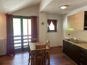 a kitchen with a table and chairs and a kitchen with a window at Residence Le Marmotte in Gressoney-la-Trinité