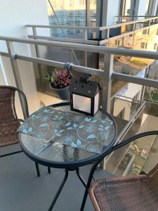 een glazen tafel met een doos op een balkon bij Oja 118 Apartment in Pärnu