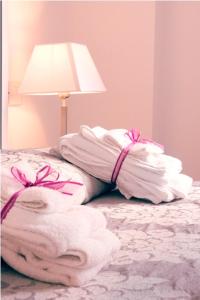 a pile of towels on a bed next to a lamp at Hotel Giulio Cesare in Rimini