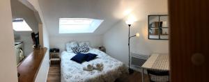 a small bedroom with a bed with shoes on it at Studio La Belle Vie in Suresnes