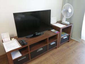 telewizor z płaskim ekranem siedzący na drewnianym centrum rozrywki w obiekcie Apartament dla turystów w Tychach