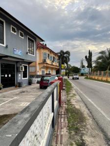 a street with cars parked on the side of a road at Wan Guesthouse in Tumpat