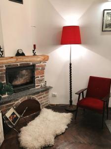 リヴィウにあるАпартаменты старого Львоваのリビングルーム(暖炉、赤い椅子付)