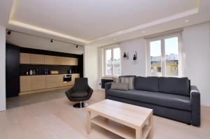 a living room with a couch and a coffee table at Victus Apartamenty, Apartament Aura in Sopot