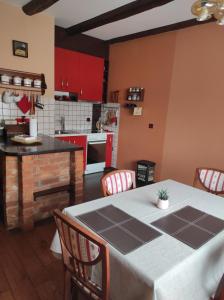 a kitchen with a table with chairs and red cabinets at Studio apartman Vuković in Varaždin