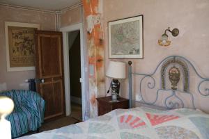 a bedroom with a bed and a lamp and a door at Grand-Varennes in Serbonnes
