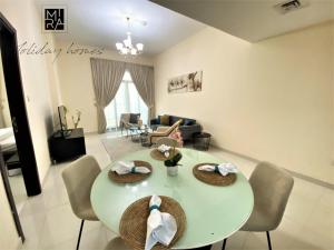a dining room and living room with a table and chairs at Spacious one bedroom in Al Jadaf - 5 min to metro in Dubai
