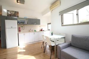 a kitchen and living room with a table and a couch at Peaceful Apartment Next To Gordon Beach By Vacay in Tel Aviv