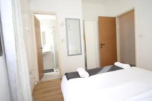 a bedroom with a white bed and a mirror at Peaceful Apartment Next To Gordon Beach By Vacay in Tel Aviv