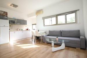 a living room with a couch and a table and a kitchen at Peaceful Apartment Next To Gordon Beach By Vacay in Tel Aviv