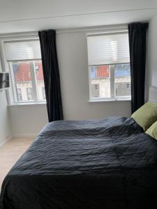 łóżko w sypialni z 2 oknami w obiekcie CITY LUX APARTMENT, 2 FULL BATHROOMs, 3v w Kopenhadze