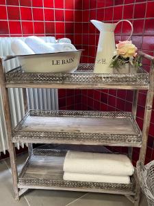 a metal shelf with towels on it in a bathroom at Historisches Gästehaus Au Faucon in Wissembourg