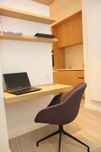un ordenador portátil sentado en un escritorio con una silla en STUDIO61 en Gante