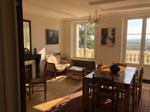 Grand-Varennes في Serbonnes: غرفة معيشة مع طاولة وكراسي ومدفأة