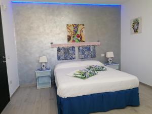 マリーナ・ディ・パルマにあるSciascia Apartmentのベッドルーム1室(ベッド1台、テーブル2台、ランプ2つ付)