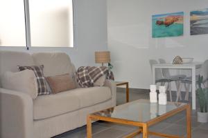 a living room with a couch and a coffee table at The blue house las Canteras in Las Palmas de Gran Canaria