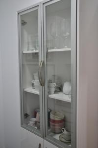 um armário branco com copos e pratos em The blue house las Canteras em Las Palmas de Gran Canárias
