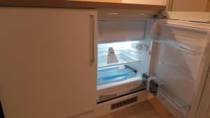 un frigorifero vuoto con la porta aperta in una cucina di Apartma, glamping Na koncu vasi a Ljutomer