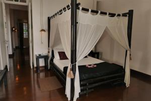 a bedroom with a black bed with a canopy at Aram Yamí Boutique Hotel in Salvador