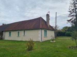 ein weißes Haus mit einem braunen Dach auf einem Hof in der Unterkunft Le domaine du bengal à 2 pas de BEAUVAL in Veuil