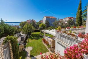 a garden on the roof of a building with flowers at Ivan & Anka apartments BOJKO in Selce