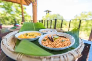 una mesa con tres tazones de comida. en Rock Violet Lakefront Cabanas & Restaurent, en Tangalle
