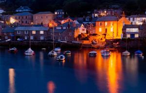 a group of boats in a harbor at night at Large cottage, 3 beds all en-suite, small village location overlooking Mousehole in Penzance