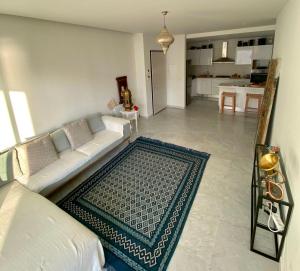 uma sala de estar com um sofá branco e um tapete em Dar Sheherazade em Hammamet