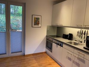 a kitchen with white cabinets and a sink at Saunahäuschen in Schmilau