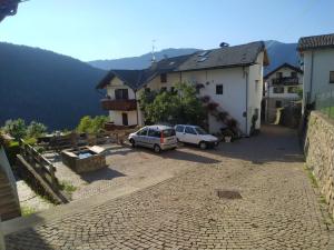 une rue avec deux voitures garées dans un village dans l'établissement Casa in valle, à Sicina