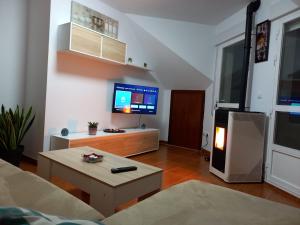 uma sala de estar com um sofá e uma televisão em Altamira em Caldas de Reis