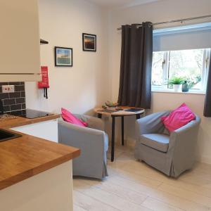 een keuken met 2 stoelen en een tafel en een raam bij Sweet Suites Residence in Lytham St Annes