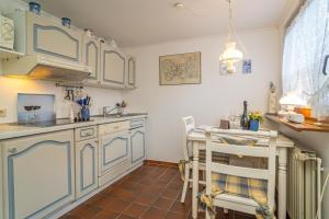 提努姆Schallers Hüs 5 - Bungalow的厨房配有蓝色橱柜和桌椅