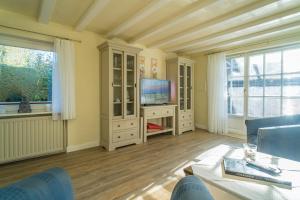 提努姆Schallers Hüs 5 - Bungalow的带电视和沙发的客厅