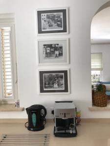 a room with a toaster and pictures on the wall at Shimmers, stunning, stylish West Coast Villa in Saint Peter