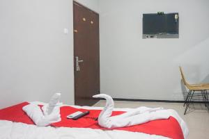 a bed with two white swans on it at RedDoorz Plus @ Kalpataru in Rampal