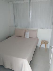 ein weißes Schlafzimmer mit einem Bett und einem Tisch in der Unterkunft Curta Milagres 31,condominio Morada do Toque in São Miguel dos Milagres + 12 Fotos