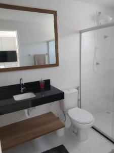 ein Badezimmer mit Toilette, Waschbecken und Spiegel in der Unterkunft Curta Milagres 31,condominio Morada do Toque in São Miguel dos Milagres