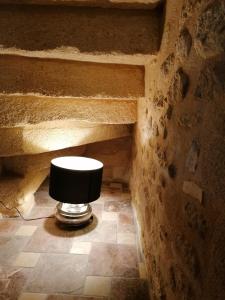 un bagno con sgabello nero su un muro di pietra di Jim cosy & spa a Saint-Hilaire-dʼOzilhan