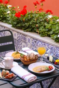 a table with plates of food and drinks and flowers at Vincci Alfama in Lisbon