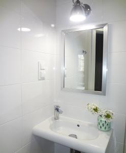 a white bathroom with a sink and a mirror at Holiday Hill Apartamenty Neli in Karpacz