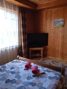 a bedroom with a bed with two pink towels on it at Карпатські ночі in Yaremche