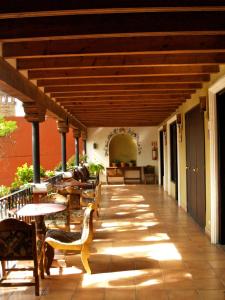 zewnętrzne patio ze stołami i krzesłami oraz drewnianym sufitem w obiekcie Hotel Ana Catalina and Suites w mieście San Miguel de Allende