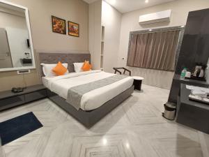 ein Schlafzimmer mit einem großen Bett und einem großen Spiegel in der Unterkunft Hotel Shri Anand Dham, Nathdwara - 125 Meters away from the temple in Nāthdwāra