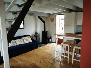 a living room with a blue couch and a kitchen at Maison de pêcheur Wissant plein centre in Wissant